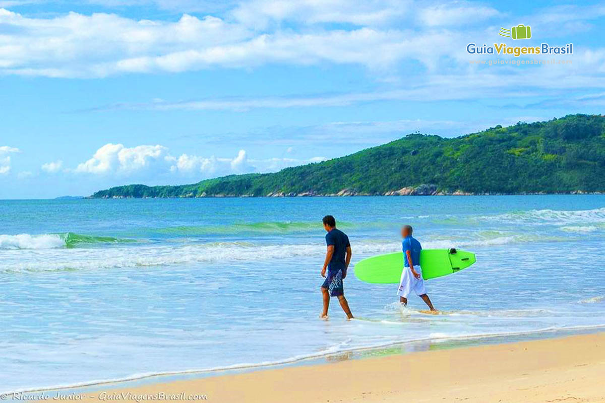 Imagem de surfistas no pico da onda na Praia Mariscal.