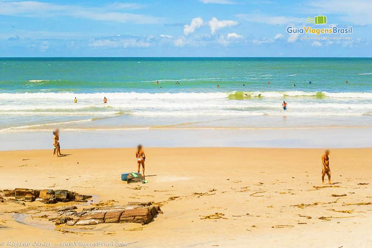 Imagem de uma surfista na areia da praia.