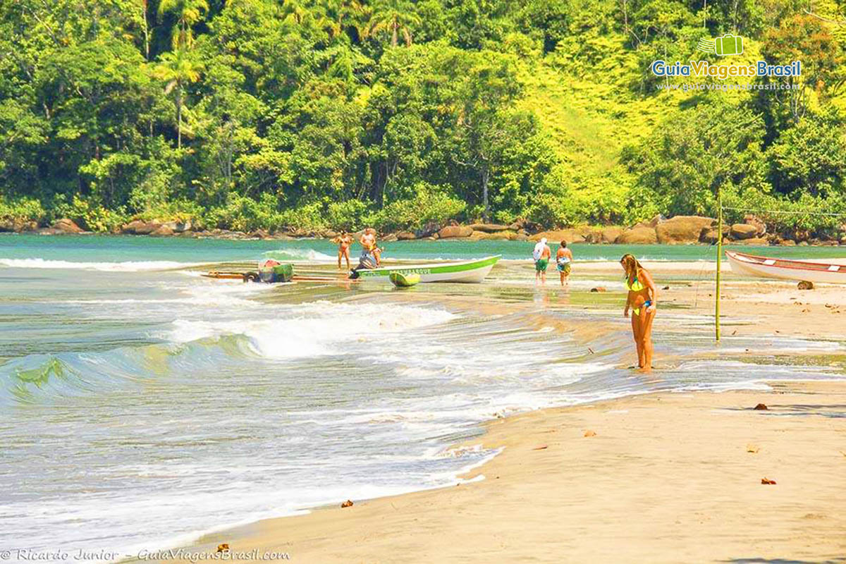 Imagem de uma moça admirando a transparência das águas na Praia de Castelhanos.