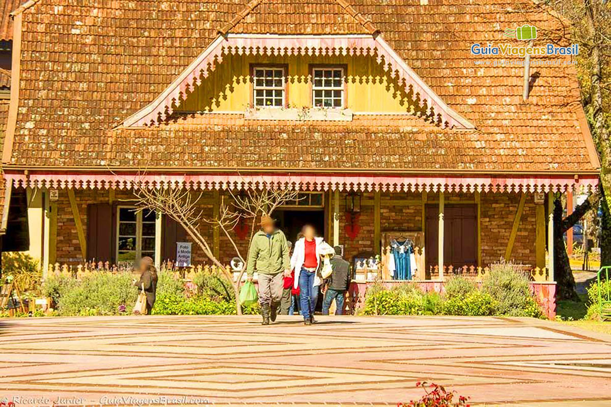 Imagem de turistas saindo da loja na bela praça.