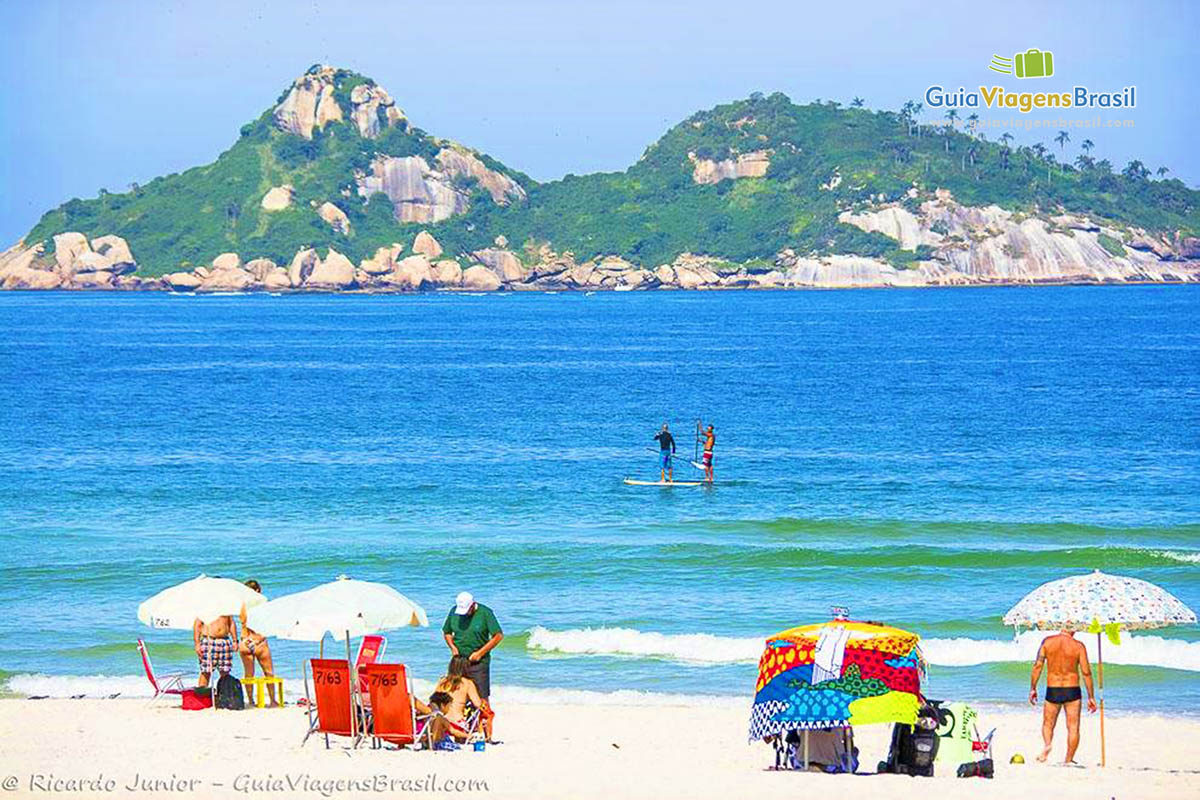 Imagem de turistas nas areias da Praia Barra da Tijuca.