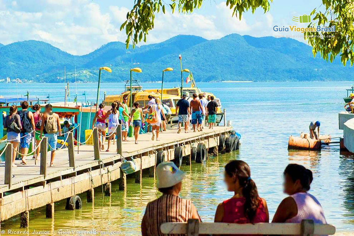 Imagem de turistas indo para o barcos que levam para passeio.