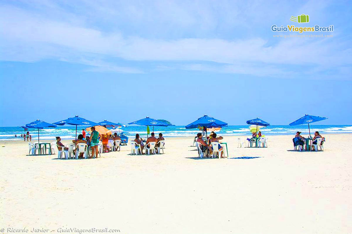Imagem de visitantes aproveitando o dia maravilhoso na Praia Riviera de São Lourenço.