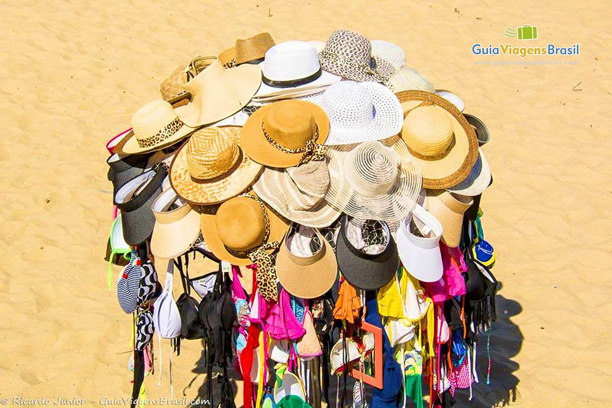 Imagem de chapéus, biquinis, cangas que as pessoas vendem na praia.