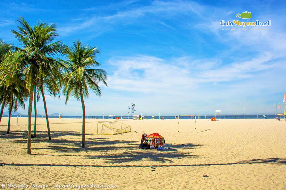 Imagem de vendedor ambulante nas areia da praia.