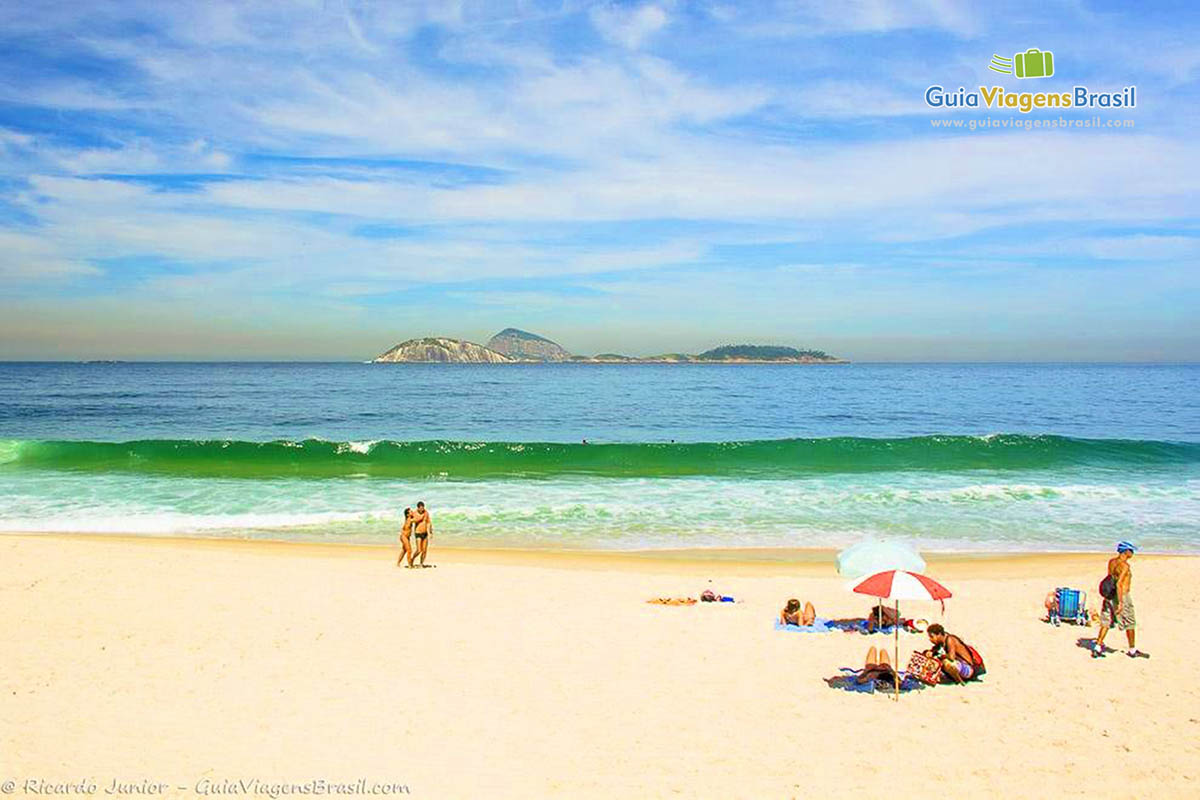 Imagem de vendedor oferecendo suas mercadoria para frequentadores da praia.