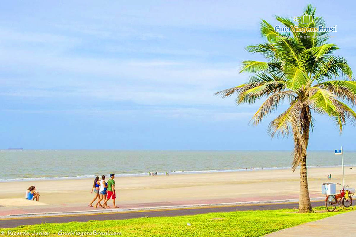 Imagem de turistas na areia da Praia São Marcos.